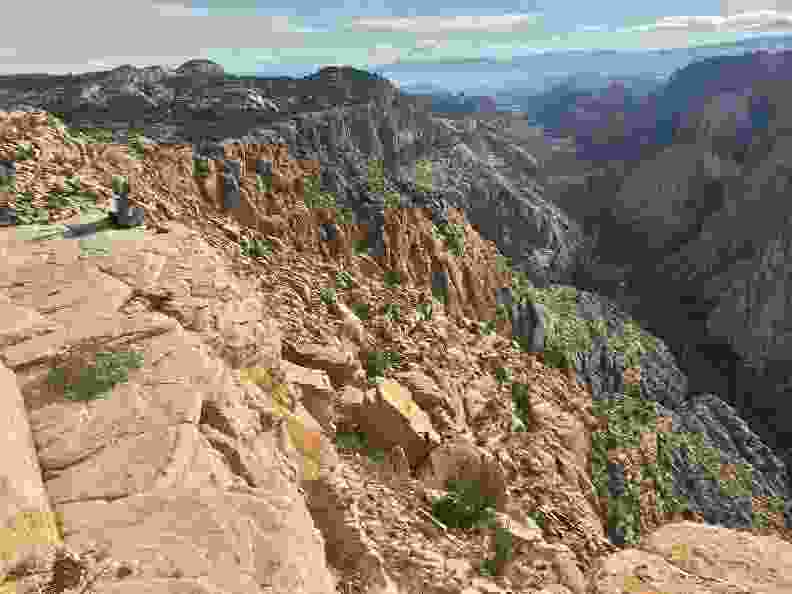 Man Sitting at the edge of a ravine on the Red Mountain Trail located in Dammeron Valley near St George Utah