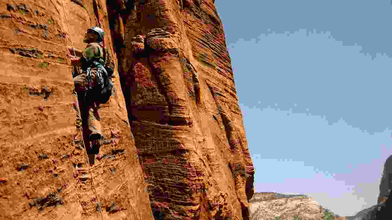 Man Climbing cliff in Zion National Park