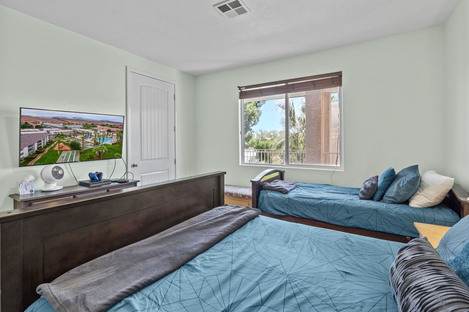 Second bedroom (picture taken with a wide lens!) with single and double beds.